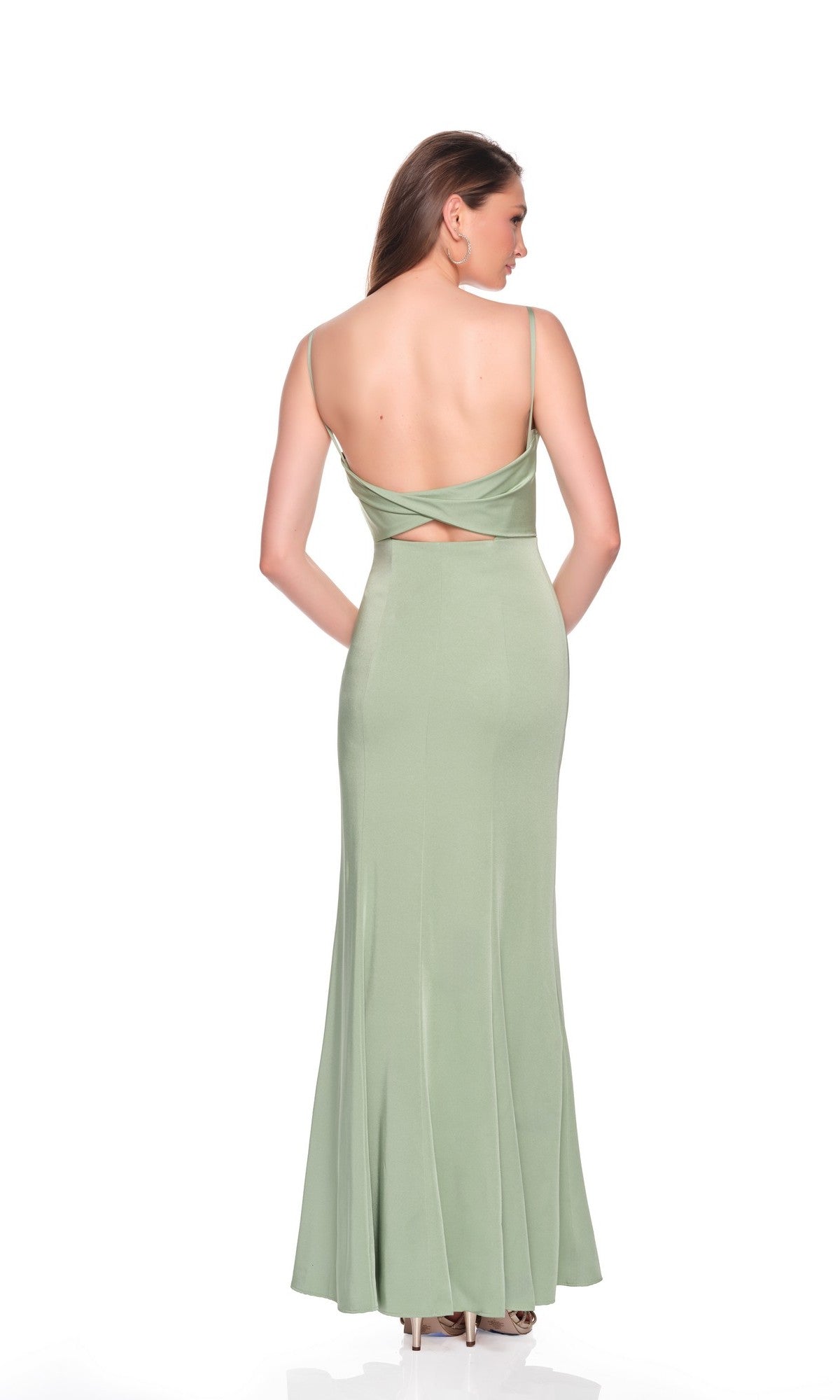 A woman in the Dave and Johnny 12407 Long Prom Dress—a light green, sleeveless, floor-length gown with thin straps and an open back—stands facing away from the camera.